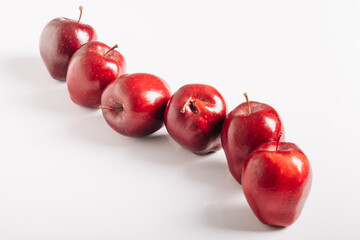A row of juicy and bright red apples isolated on a white background
