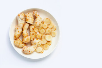 Fresh galangal on dish plate isolated on white
