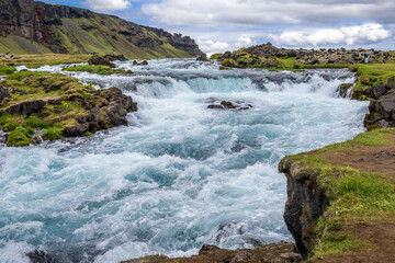Tourist looks on unnamed waterfall next to so called Ring Road in southern Iceland