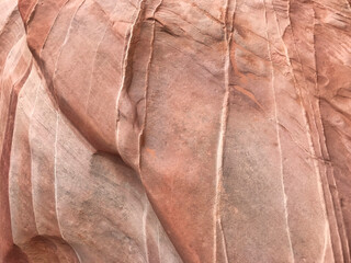 Rötlicher Felsen mit Wölbungen und weißen Linien