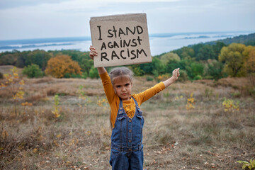 Kid holding a poster with anti-racism message, activism and human rights movement