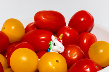 Detail on a cute little unicorn head looking sexy in a flood of orange and roma tomatoes