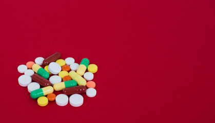 Obraz na płótnie Canvas Medical background with pills and capsule on red background.Assorted pharmaceutical medicine pills, tablet. Heap of various assorted medicine tablets and pills different colors. Health care. Top view