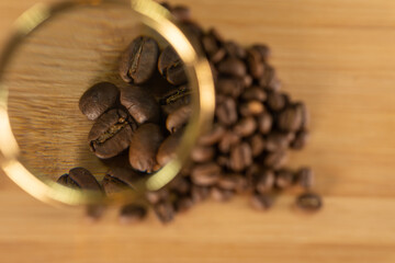 Coffee beans under the lens are scattered around the blurred background of a serkh shot for advertising enlarged grains in the corner
