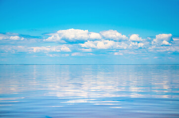 Fototapeta na wymiar Seascape background vivid blue sky with clouds reflect in sea
