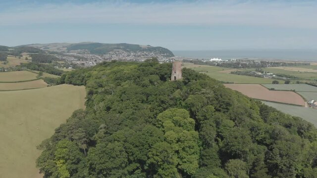 Aerial view of ancient stone watchtower in forest, countryside landscape, near Dunster, Somerset