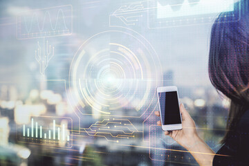 Double exposure of technology sketch hologram and woman holding and using a mobile device.