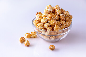 Sweet caramel popcorn in glass bowl. Close up. White background. Isolate.