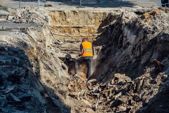 Man Examining An Excavation Of Old Broken Water Supply Or Sewer Pipeline