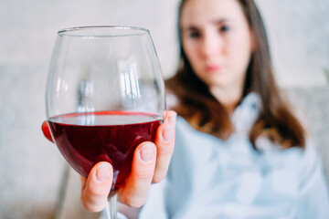 Girl looks at a glass of wine.