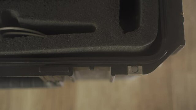 Top shot - hand opens latch of protective hard case used for professional gear