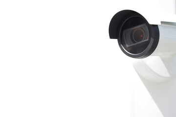 White compact cctv camera with deep shadow on white wall background in bright sunlight