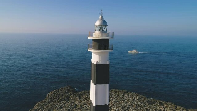 Lighthouse on rocky cliff near sea