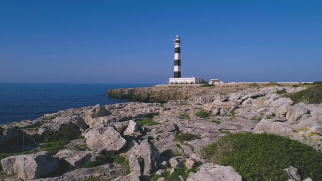 Lighthouse on rocky cliff near sea