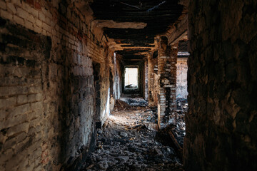 Fototapeta na wymiar Burnt old house interior. Ruined coridor walls in black soot. Consequences of fire