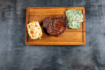 grilled beef steak and eggplant sauce, potatoes on plate isolated on black background. mexican steak food
