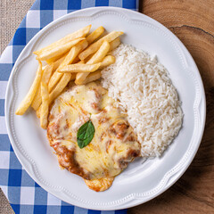 Parmegiana Steak also known as Filet Parmegiana. .Accompanied by rice and chips