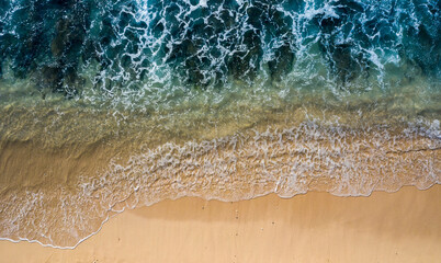 Fototapeta na wymiar Drone view directly above of tidal waves splashing along a white sand beach. Image taken in Bali Indonesia.