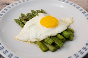 Fried egg with asparagus. Milanese traditional dish.