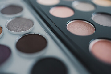cosmetics and beauty, close-up of two similar eyeshadow palettes with neutral nude tones next to each other metaphor of competition