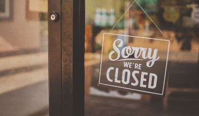 Label 'Sorry we're closed' notice sign wood board hanging on door front coffee shop. vintage style.