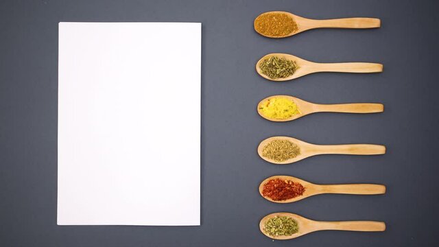 Blank paper and wooden spoons appear and spices appear in spoons - Stop motion 