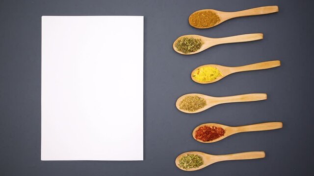Eco friendly wooden spoons with spices moving next to paper for recipe - Stop motion 