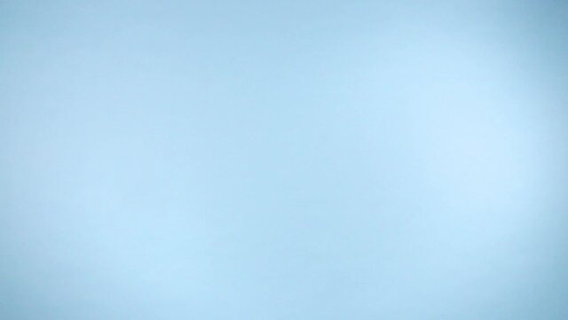 Uncooked italian pasta flying up on a colorful light blue background in slow motion.