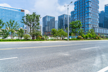 Fototapeta na wymiar empty asphalt road near glass office building
