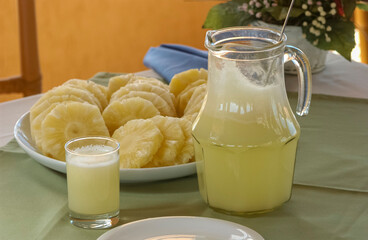 Pineapple. Juice and cut fruit set on the table.