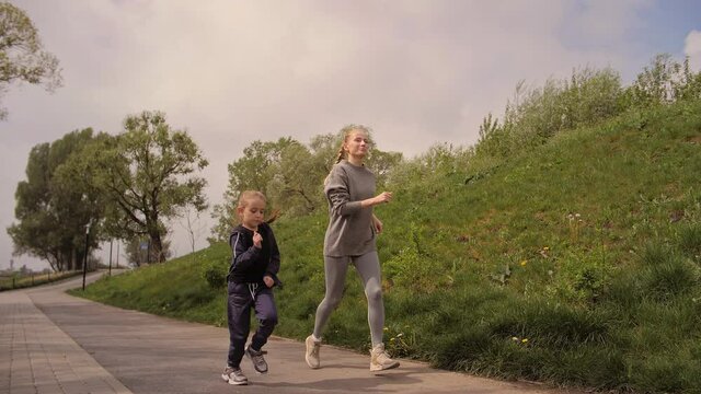 4K Mother and daughter running joggin outdoor in the park