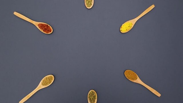 Wooden spoons with various spices appear in center - Stop motion 