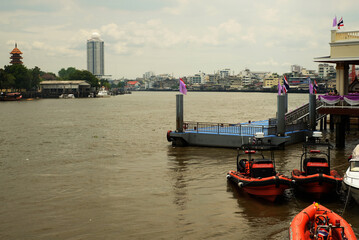 A pier with orange speed boats  for emergency case standby in the river