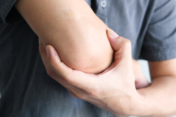 Men use their hands to hold their elbows and He had pain at the elbows.. Painful Health and medical concepts