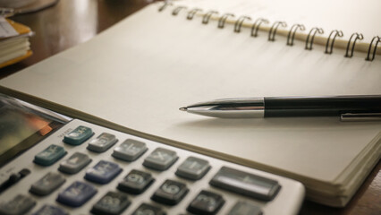 a Pen on a notebook with a Calculator