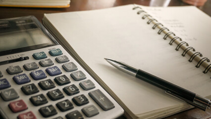 a Pen on a notebook with a Calculator