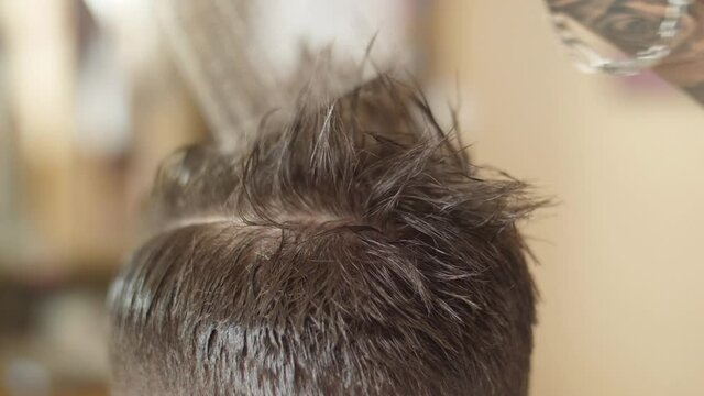 barber combing customer hair with comb slow motion