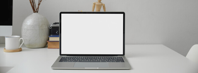 Modern office table with computer, cup, camera, stationery, decorations and copy space