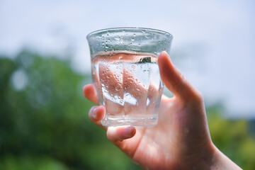 水の入ったグラスを持つ女性の手
