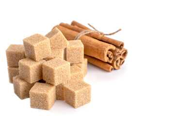 brown sugar cubes and cinnamon sticks on a white isolated background