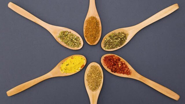 Wooden spoons with spices changing places in circle - Looping Stop motion 