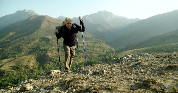 Young caucasian guy going oh a hike adventure. Male model trekking on mountain paths, representing active way of life and freedom 4k footage