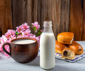Breakfast rolls with chocolate filling and milk on a wooden rustic background