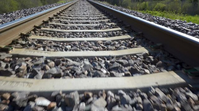 The small black rocks on the metal railroad track