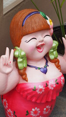 Stucco doll, woman standing, raise fingers