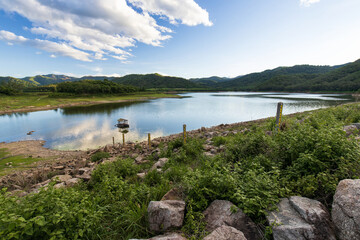 Lake dam water reservoir, Water level measurement in lake dam water reservoirwith with mountain forest in beautiful clouds and blue sky, reservoir for innovations in agriculture industry..