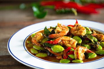 Stir fried Sato and shrimp with curry paste (thai food) in white dish put on old wooden table