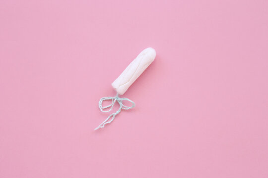 white hygiene tampon on a pink background