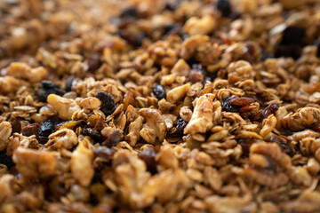 Healthy granola cereal with oats, pumpkin seeds, walnuts, and raisins, side view