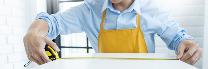 Men's hands hold a measuring tape measuring with flexible ruler for home renovation. repair,...